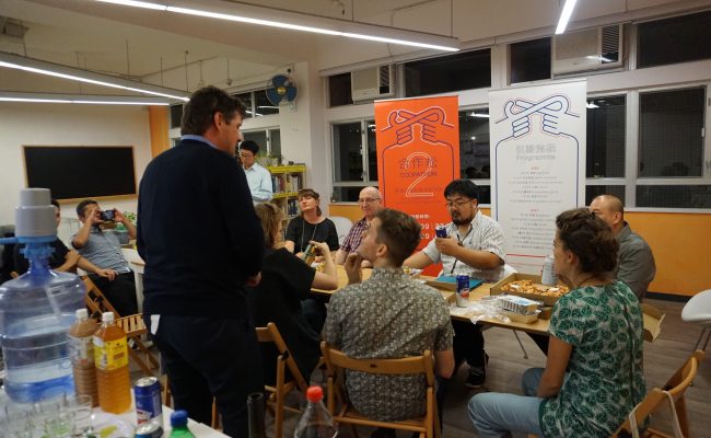 Trebor talking to a small group of people at the Platform Cooperativism Consortium's 2018 conference in Hong Kong.