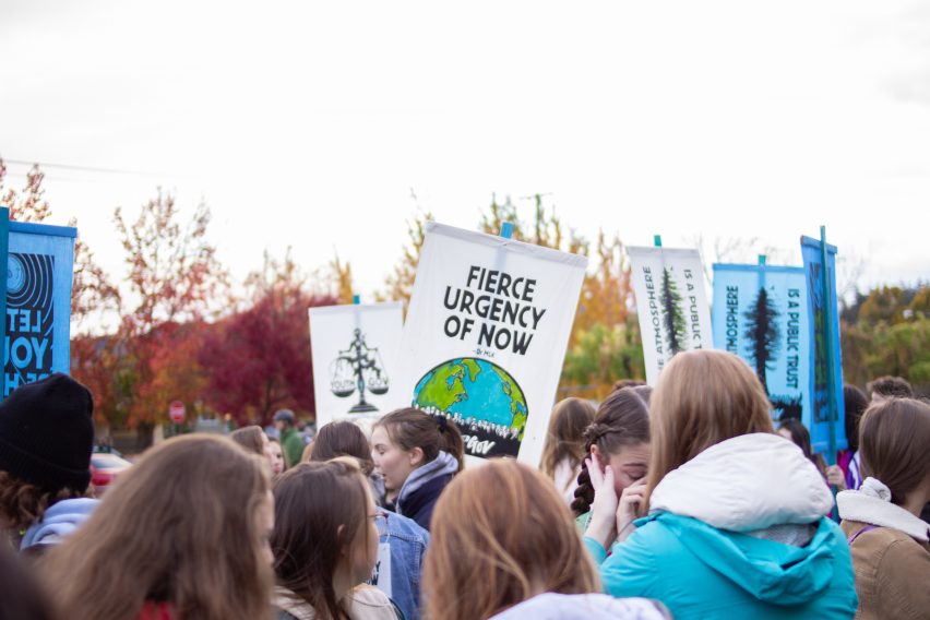 People holding up protest sign.